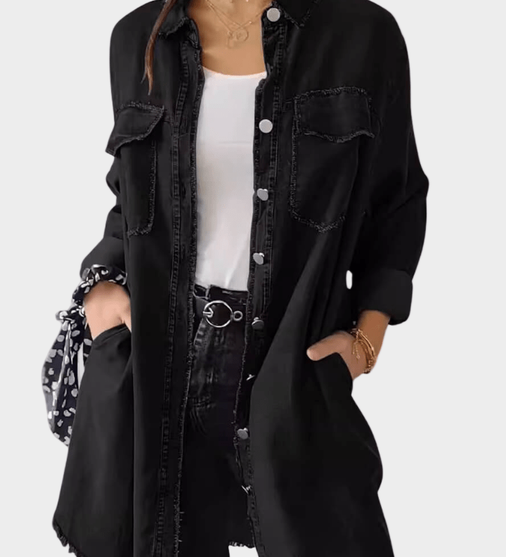Woman wearing a long denim shirt dress with rolled sleeves and side pockets