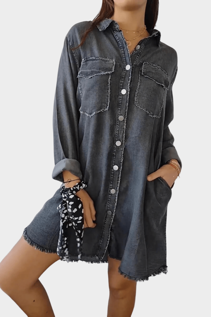Woman wearing a long denim shirt dress with rolled sleeves and side pockets