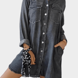 Woman wearing a long denim shirt dress with rolled sleeves and side pockets