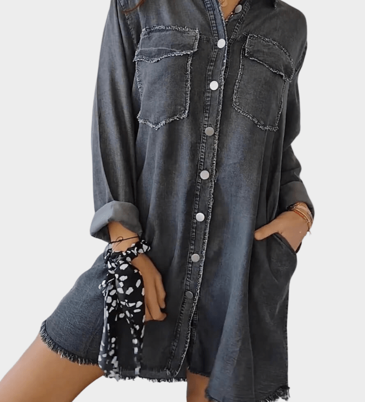 Woman wearing a long denim shirt dress with rolled sleeves and side pockets