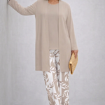 Woman wearing a cream three-piece cardigan, top and trousers co-ord set