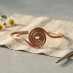 Spiral copper anklet with a hand-coiled centre design