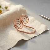 Copper hand spiral jewellery worn across the hand