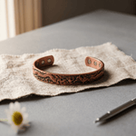 Copper cuff bracelet with a hand-embossed dragon design