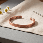 Hand-stamped flower pattern on a solid copper cuff bracelet