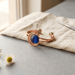 Copper cuff bracelet set with three blue-grey stones