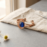 Copper cuff bracelet set with three blue-grey stones
