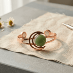 Copper cuff bracelet with a hand-set green stone