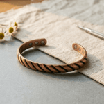 Copper cuff bracelet with a ridged texture and hidden magnets