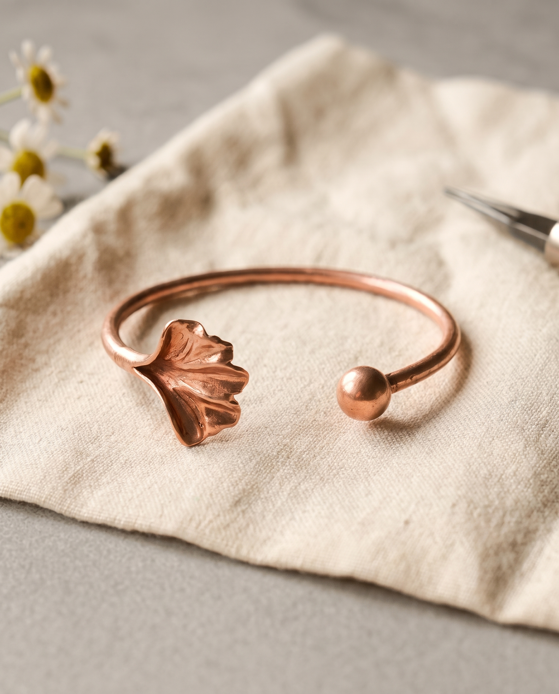 Handformed copper cuff with sculpted flower detail at one end